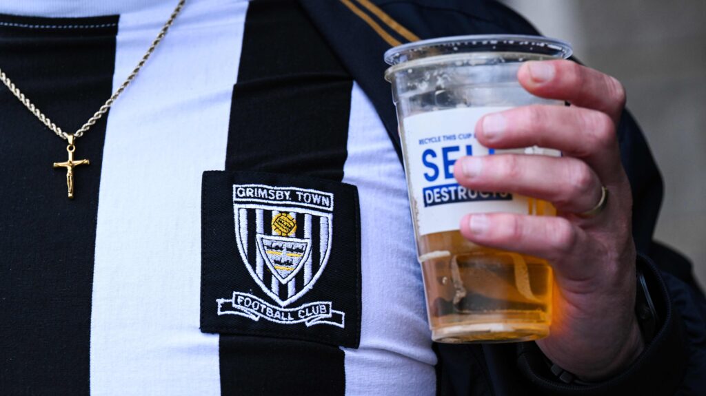 Grimsby football fan holds pint of beer