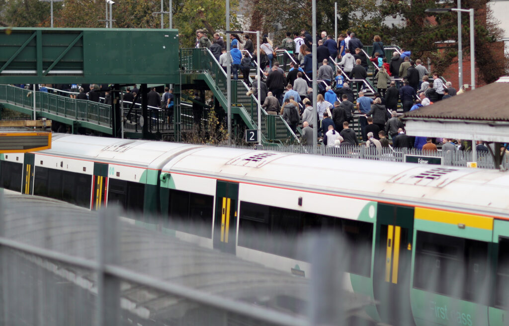 Large crowd of football fans coming or going from train station